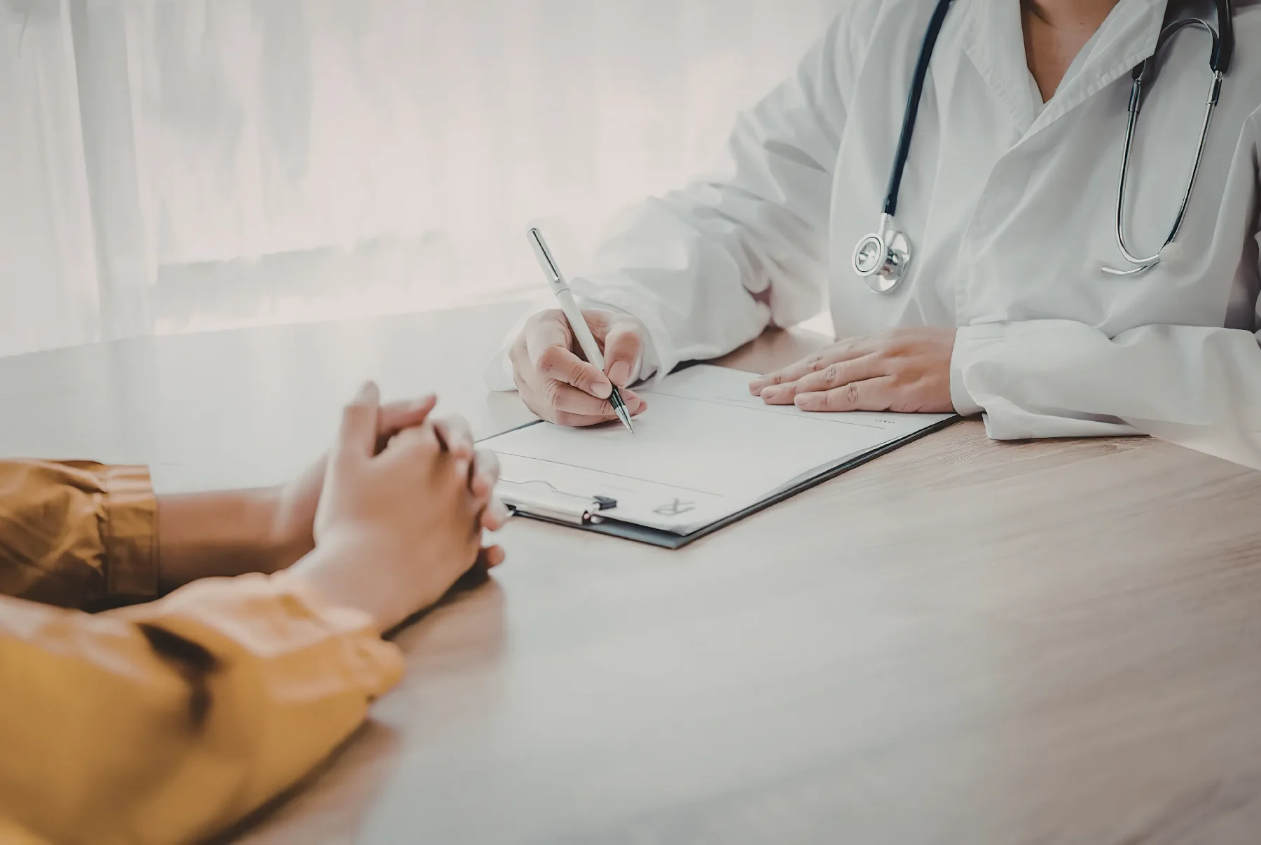 A professional consultation taking place across a desk, representing booking an initial discussion about stopping smoking